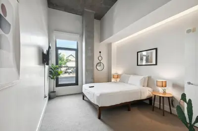 a white bedroom with a bed and a window at Cloud Nine Retreat at Espadin in Denver