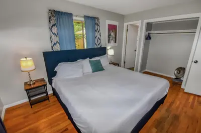 a bedroom with a large white bed with a blue headboard at Super Cute Five Bedroom Home in Denver Perfect For Girls Trips in Denver