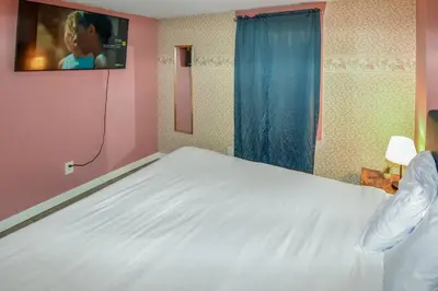 a bedroom with a white bed with a tv on the wall at Super Cute Five Bedroom Home in Denver Perfect For Girls Trips in Denver