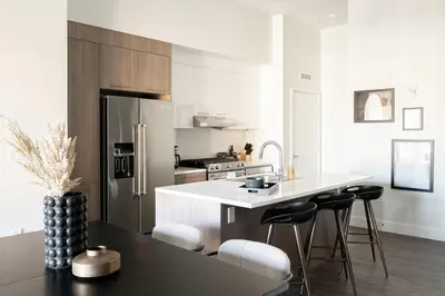 a kitchen with a refrigerator and a counter with stools at Relaxed Elegance at Espadin in Denver