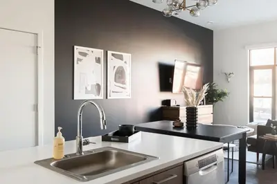 a kitchen with a sink and a black wall at Relaxed Elegance at Espadin in Denver