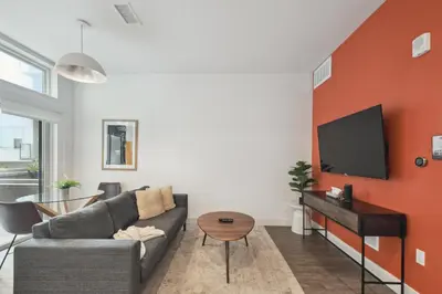 a living room with a couch and a tv on a wall at Southwestern Charm Studio at Espadin in Denver