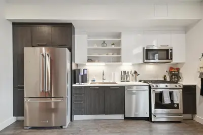 a kitchen with stainless steel appliances and wooden cabinets at Southwestern Charm Studio at Espadin in Denver