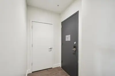 a hallway with a black door and a white wall at Sleek & Chic Comforts at Espadin in Denver