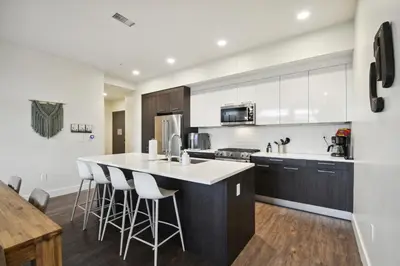 a kitchen with a white counter and bar stools at Sleek & Chic Comforts at Espadin in Denver