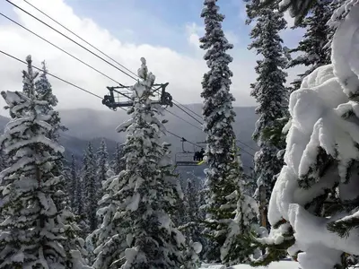 a ski lift with snow covered trees on a mountain at Luxury 2 bed 2 bath Condo in River Run with Pool and Hot Tub in Keystone