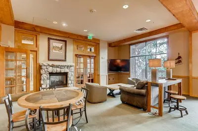 a living room with a table and a fireplace at Luxury 2 bed 2 bath Condo in River Run with Pool and Hot Tub in Keystone