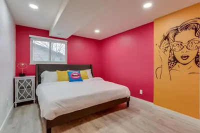 a bedroom with a bed and a colorful wall at Pop Art Oasis with Karaoke Mini Golf Hot Tub and Pool in Arvada