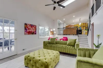 a living room with green furniture and a ceiling fan at Pop Art Oasis with Karaoke Mini Golf Hot Tub and Pool in Arvada