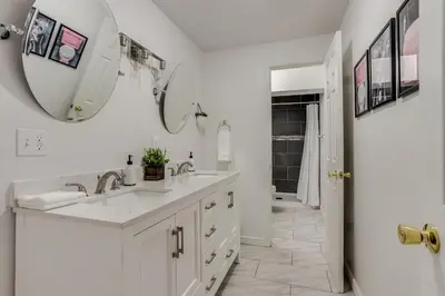 a white bathroom with a sink and a mirror at Pop Art Oasis with Karaoke Mini Golf Hot Tub and Pool in Arvada