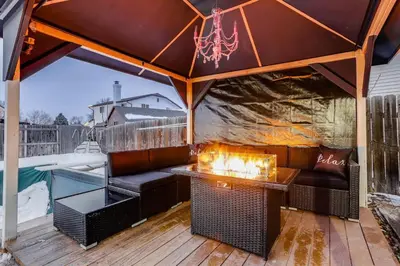 an outdoor patio with a table and a fireplace at Pop Art Oasis with Karaoke Mini Golf Hot Tub and Pool in Arvada