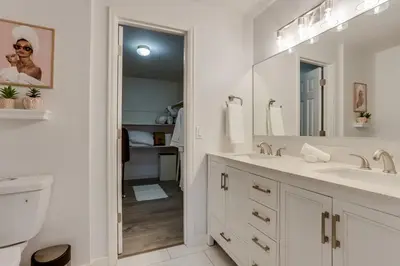 a white bathroom with a sink and a mirror at Pop Art Oasis with Karaoke Mini Golf Hot Tub and Pool in Arvada