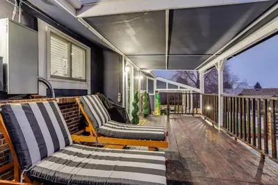 a porch with two couches on a deck at Pop Art Oasis with Karaoke Mini Golf Hot Tub and Pool in Arvada