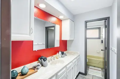 a bathroom with two sinks and a red wall at The Evergreen Oasis I Red Rocks I Morrison in Morrison