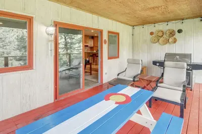 a room with a table and chairs on a porch at The Evergreen Oasis I Red Rocks I Morrison in Morrison
