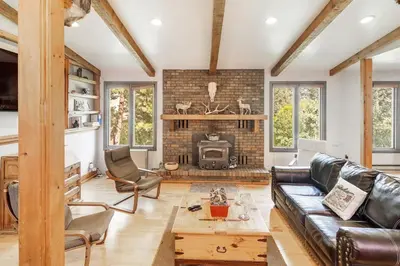 a living room with a leather couch and a fireplace at The Evergreen Oasis I Red Rocks I Morrison in Morrison