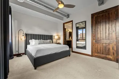 a bedroom with a bed and a wooden door at Chic Loft Heart of RiNo in Denver