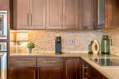 a kitchen with wooden cabinets and a coffee maker on the counter at Chic Loft Heart of RiNo in Denver