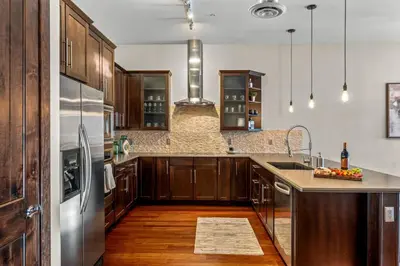 a kitchen with wooden cabinets and a stainless steel refrigerator at Chic Loft Heart of RiNo in Denver