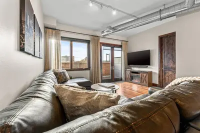 a living room with a couch and a television at Chic Loft Heart of RiNo in Denver