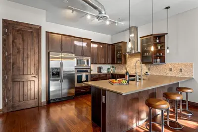 a kitchen with wooden cabinets and stainless steel appliances at Chic Loft Heart of RiNo in Denver
