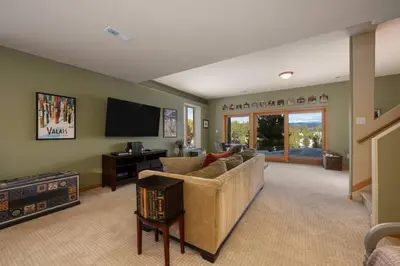 a living room with a couch and a flat screen tv at Stunning Mountain Retreat with View and Private Hot Tub in Tabernash