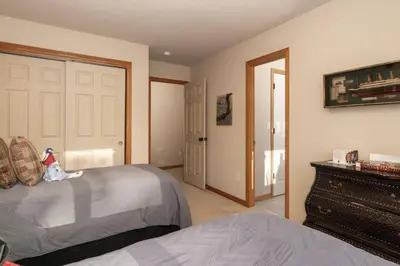a bedroom with a bed and a dresser and a door at Stunning Mountain Retreat with View and Private Hot Tub in Tabernash
