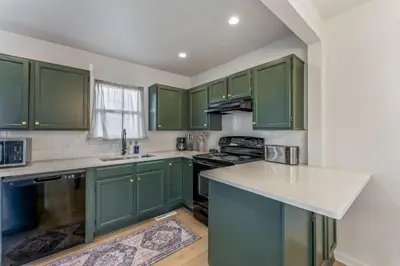 a kitchen with green cabinets and a white counter top at Central Denver Hangout with Huge Backyard in Denver