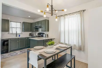 a kitchen with green cabinets and a dining room table at Central Denver Hangout with Huge Backyard in Denver