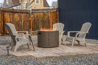 three chairs and a fire pit in a backyard at Central Denver Hangout with Huge Backyard in Denver