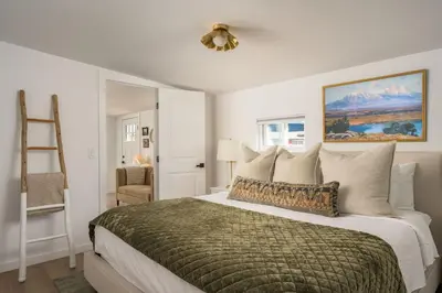 a bedroom with a large bed with a green blanket at The Wild Rose Gatehouse in Arvada