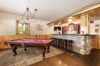 a pool table in a room with a stone fireplace at Wagon Ranch Ultimate Retreat with Hot Tub in Tabernash