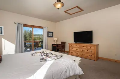 a bedroom with a bed and a flat screen tv at Wagon Ranch Ultimate Retreat with Hot Tub in Tabernash