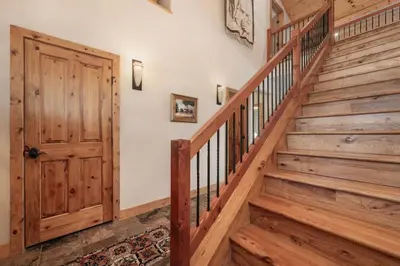 a wooden staircase in a house with a wooden door at Wagon Ranch Ultimate Retreat with Hot Tub in Tabernash