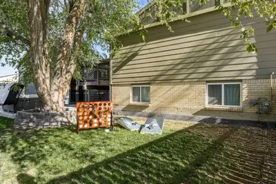 a house with a sign in the grass next to a tree at The Ultimate Hangout House in Denver