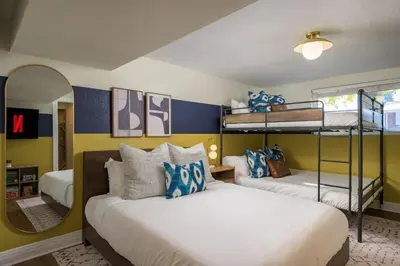 a bedroom with two bunk beds and a mirror at The Ultimate Hangout House in Denver
