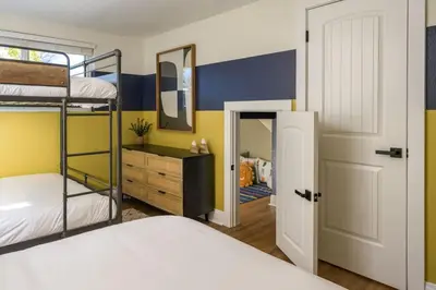 a bedroom with two bunk beds and a mirror at The Ultimate Hangout House in Denver
