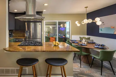 a kitchen with a counter and a kitchen island with stools at The Ultimate Hangout House in Denver