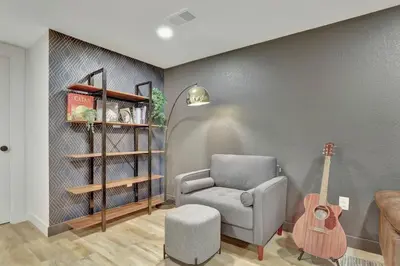 a living room with a chair and a guitar at Brand New Arvada Guest Suite Sauna Fire Pit in Arvada