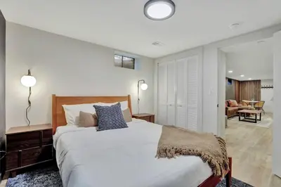 a bedroom with a large bed and a living room at Brand New Arvada Guest Suite Sauna Fire Pit in Arvada