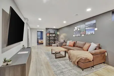 a living room with a couch and a flat screen tv at Brand New Arvada Guest Suite Sauna Fire Pit in Arvada