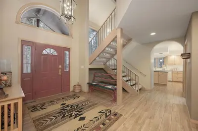 a living room with a staircase and a red door at Trailside Mountain Retreat with Private Hot Tub in Winter Park