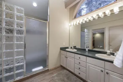a bathroom with two sinks and a shower and a mirror at Trailside Mountain Retreat with Private Hot Tub in Winter Park