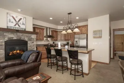 a kitchen and living room with a fireplace at Hot Tub Mountain Views Steps to Trails in Winter Park