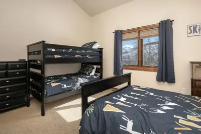 a bedroom with two bunk beds and a dresser at Hot Tub Mountain Views Steps to Trails in Winter Park