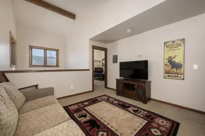 a living room with a couch and a flat screen tv at Hot Tub Mountain Views Steps to Trails in Winter Park