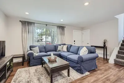a living room with a blue couch and a table at Charming Family Friendly 4bd 2ba Arvada Home in Arvada