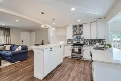 a kitchen with white cabinets and a blue couch at Charming Family Friendly 4bd 2ba Arvada Home in Arvada
