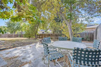 a table and chairs in a yard with a tree at Charming Family Friendly 4bd 2ba Arvada Home in Arvada