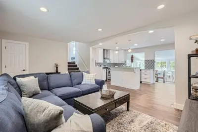 a living room with a blue couch and a kitchen at Charming Family Friendly 4bd 2ba Arvada Home in Arvada
